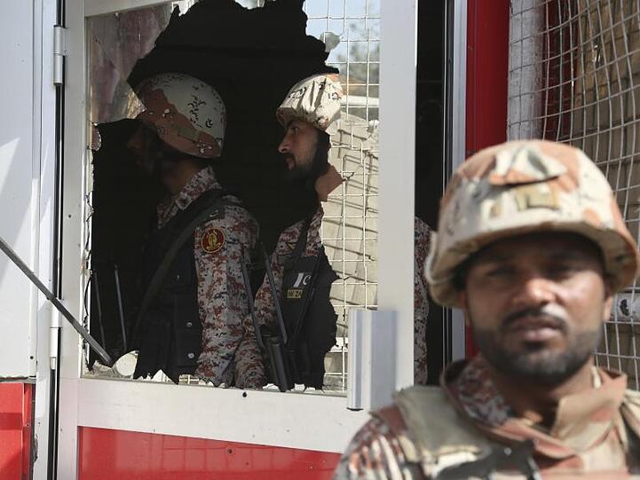 Ein pakistanischer Soldat vor einer zerstörten Scheibe des chinesischen Konsulats.