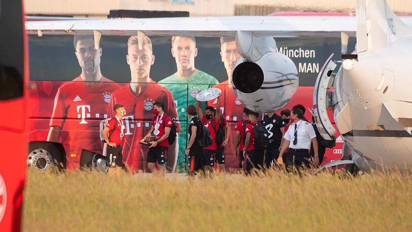 Da ist das Ding! Serge Gnabry präsentiert bei der Ankunft am Flughafen stolz die Meisterschale.