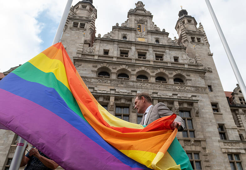 Burkhard Jung (SPD), Oberbürgermeister der Stadt Leipzig, hisst die Regenbogenflagge vor dem Neuen Rathaus.