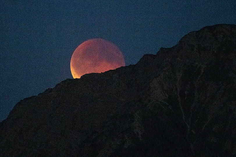 Der Vollmond geht hinter dem Nebelhorn in Oberstdorf im Allgäu auf, durch die Mondfinisternis färbt sich der Mond rot zum Blutmond, bevor er sich verdunkelt.