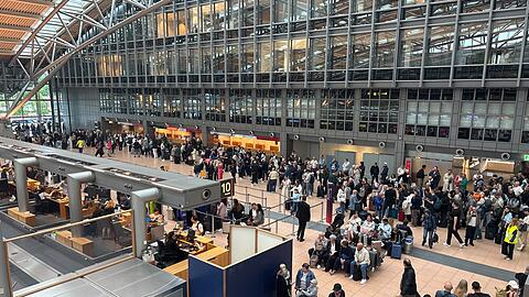Zahlreiche Menschen stehen im Terminal des Hamburger Flughafens.