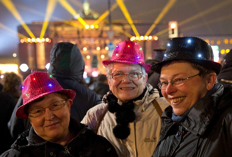 Drei Damen aus Aurich in Ostfriesland feiern bei der Silvesterparty am 31.12.2014 am Brandenburger Tor in Berlin.