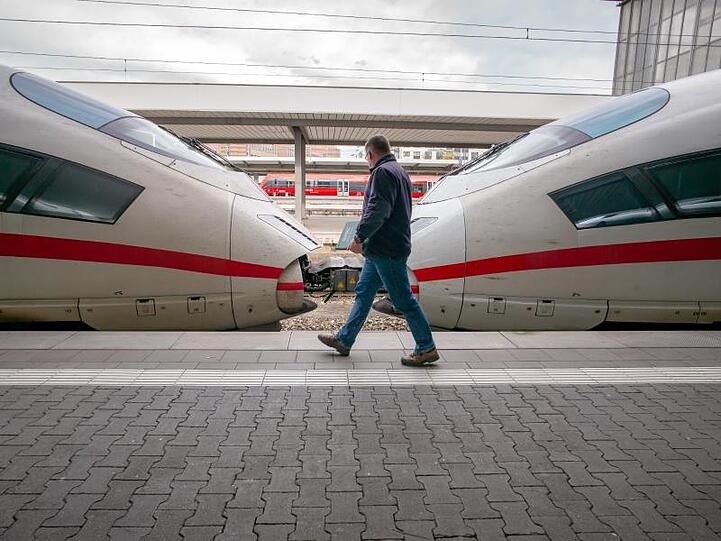 Ein Mann läuft über ein Bahnsteig am Hauptbahnhof, an dem ein ICE steht. Foto: Peter Kneffel/dpa/Archivbild