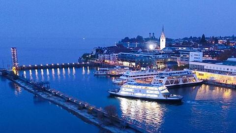 Eine Autofähre fährt zur Blauen Stunde aus dem Hafen auf dem Bodensee (Luftaufnahme). Foto: Felix Kästle/Archivbild