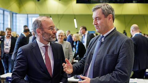 Markus Söder (r) und Manfred Weber unterhalten sich zu Beginn der CSU-Delegiertenversammlung zur Europawahl.