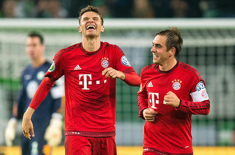 Entspannt im Triumph: Thomas Müller und Pokal-Jubilar Philipp Lahm (rechts).