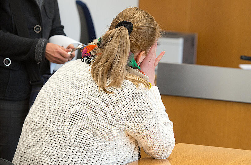 Die Angeklagte sitzt im Verhandlungssaal des Landshuter Landgerichts.
