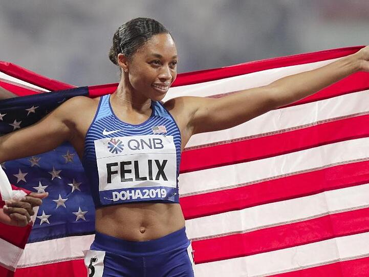 Allyson Felix posiert mit dem Sternenbanner der USA.