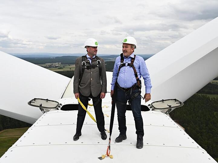 Wirtschaftsminister Hubert Aiwanger (Freie Wähler, l) und Erich Wust stehen auf einem Windrad. Foto: Nicolas Armer