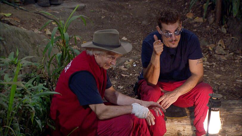 Peter Orloff und Chris Töpperwien sitzen am Lagerfeuer.