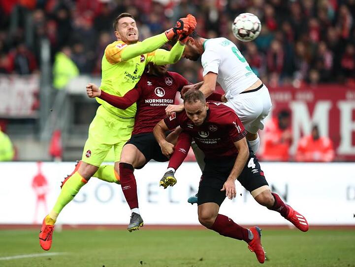 Nürnbergs Christian Mathenia (l.), Tim Leibold (M., verdeckt) und Ewerton (unten) prallen auf Bremens Martin Harnik. Foto: Daniel Karmann