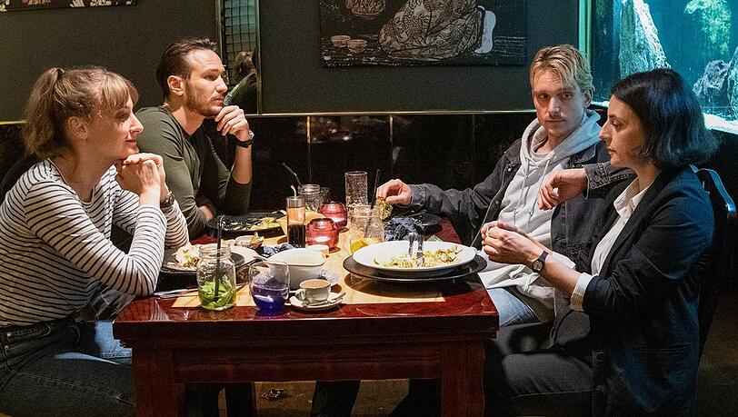 "Tatort: Das Herz der Schlange": Die Hauptkommissarinnen und Hauptkommissare feiern bei einem Abendessen den Abschluss eines Falls: Pia Heinrich (Ines Marie Westernströer, l.), Leo Hölzer (Vladimir Burlakov), Adam Schürk ( Daniel Sträßer, r.), Esther Baumann (Brigitte Urhausen).