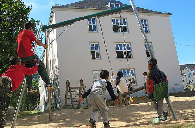 Flüchtlingskinder spielen auf dem Gelände der zentralen rheinland-pfälzischen Aufnahmeeinrichtung für Asylbegehrende in Trier auf einem Spielplatz.