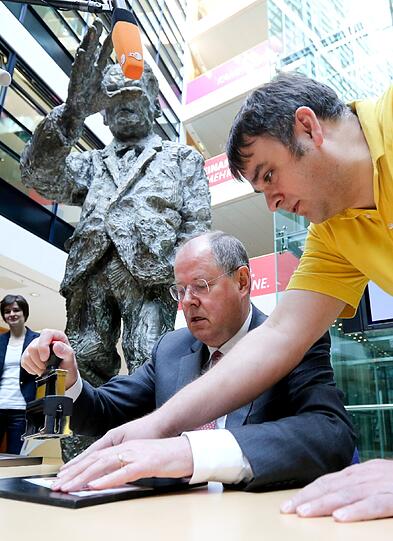 Der SPD-Kanzlerkandidat Peer Steinbrück zeigt am 04.04.2013 in der Parteizentrale in Berlin die Sonderbriefmarke zum 150. Jubiläum der SPD