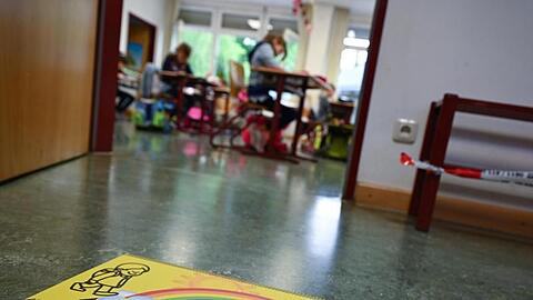 Ein Abstands-Hinweis klebt auf dem Fußboden einer Grundschule in Wiesbaden.