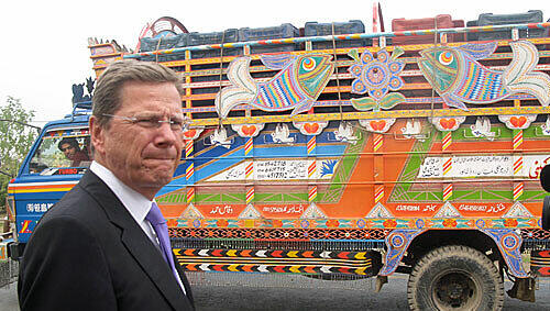 Bunte Laster in der nebligen pakistanischen Provinz, und davor ein deutscher Außenminister: Westerwelle beim Tankstopp. Bunte Laster in der nebligen pakistanischen Provinz, und davor ein deutscher Außenminister: Westerwelle beim Tankstopp.