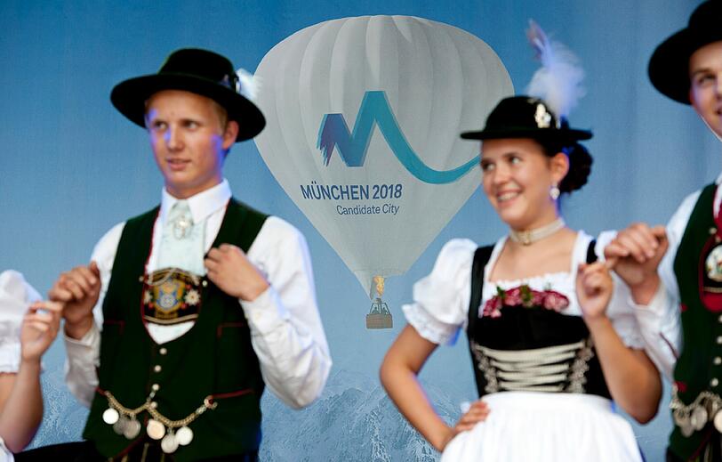 Tänzerinnen und Tänzer in bayerischer Tracht unterhalten auf dem Marienplatz das Publikum.