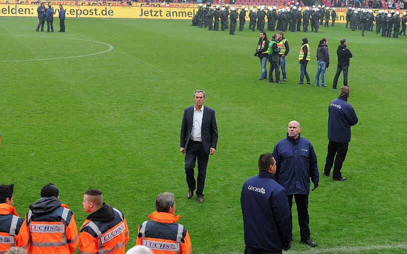 05.05.2012 Mit dem Schlusspfiff stürmen Hooligans des 1. FC Köln nach der 1:4-Niederlage gegen Bayern München den Platz und können nur von einem massiven Polizeiaufgebot in Schach gehalten werden. Zuvor waren bereits auf der Kölner Fantribüne Rauchbomben und Bengalische Feuer gezündet worden.