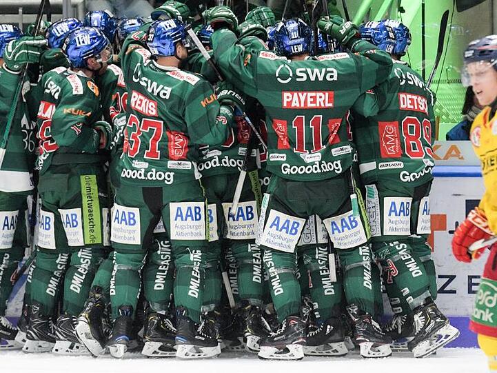 Augsburgs Spieler feiern in einer Traube den Sieg, rechts Düsseldorfs Ken Andre Olimb. Foto: Stefan Puchner