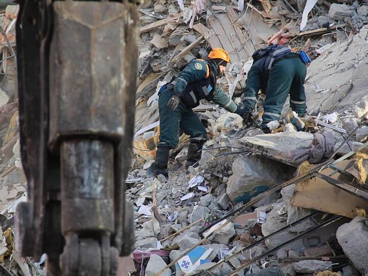 Rettungskräfte arbeiten an der Stelle, an der eine Gasexplosion das Wohngebäude teilweise zerstört hat.