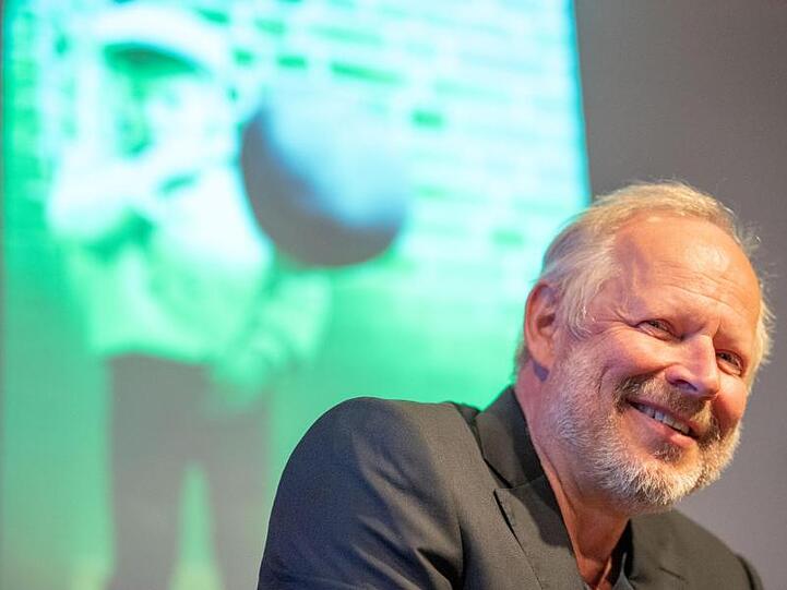 Axel Milberg, Schauspieler, sitzt bei der Lesung zu seinem Buch "Düsternbrook" auf der Bühne. Foto: Lino Mirgeler