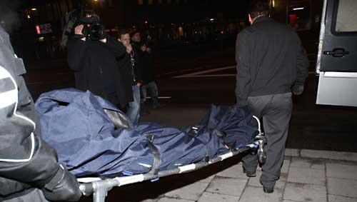 Zwei Männer tragen die Leiche des Ermordeten auf einer Bahre aus dem Haus. Zwei Männer tragen die Leiche des Ermordeten auf einer Bahre aus dem Haus.