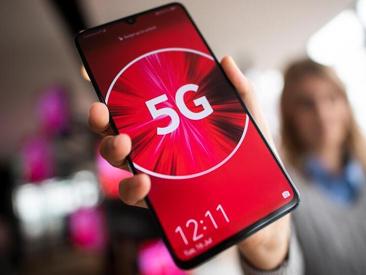 Eine Vodafone-Mitarbeiterin mit einem 5G-Smartphone.