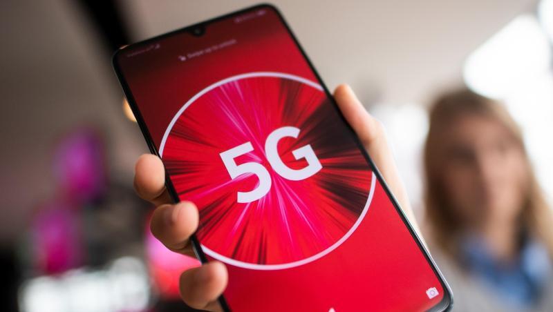 Eine Vodafone-Mitarbeiterin mit einem 5G-Smartphone. Eine Vodafone-Mitarbeiterin mit einem 5G-Smartphone.