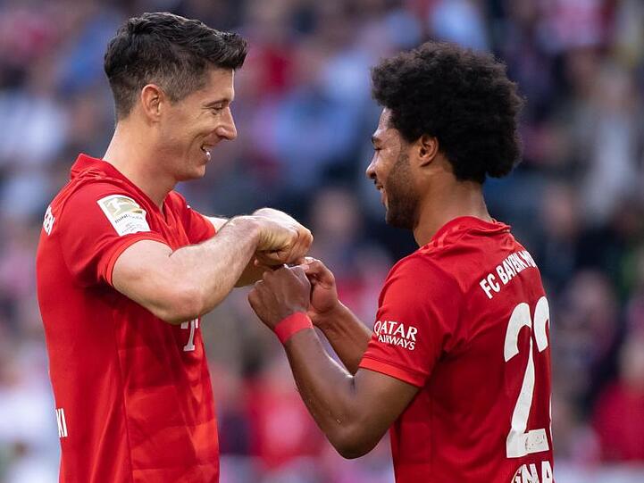 Serge Gnabry (r) gratuliert seinem Bayern-Kollegen Robert Lewandowski zum Torrekord.
