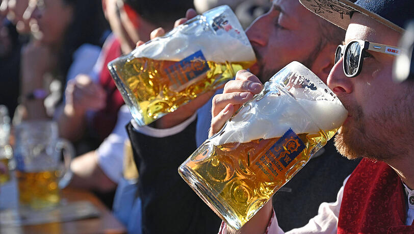 Prost! Zwei M&auml;nner lassen sich ihre Wiesn-Ma&szlig; schmecken.