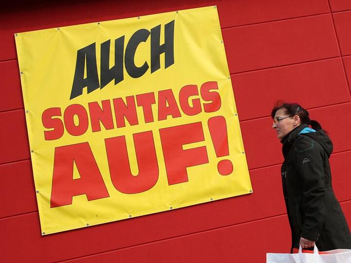 An einem Kaufhaus informiert ein Transparent über die Öffnung an Sonntagen. Foto: Bernd Wüstneck/dpa-Zentralbild/dpa/Symbolbild