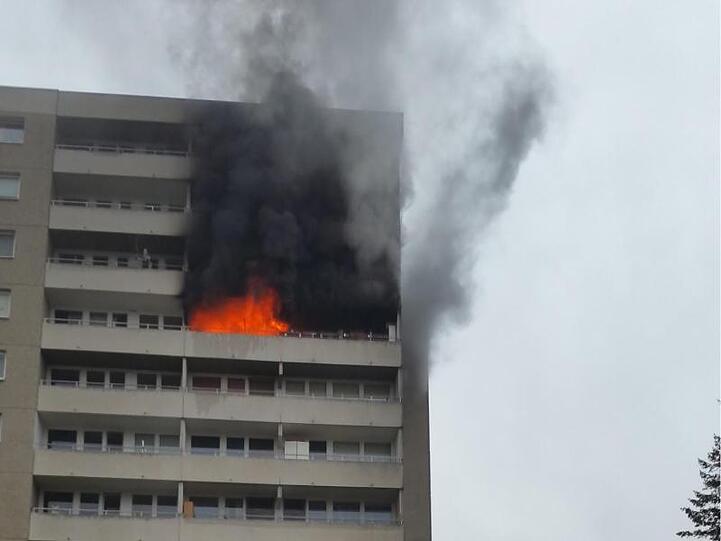 Feuerwehrleute stehen mit einem Löschzug vor einem Brennenden Hochhaus. Foto: Freiwillige Feuerwehr Puchheim-Bahnhof/dpa/Archiv