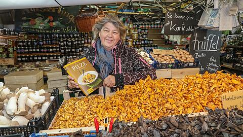 Renate Zollner mit ihrem Schwammerlbuch und ganz vielen Pfifferlingen. Vorne im Bild sind die schwarzen Herbsttrompeten.
