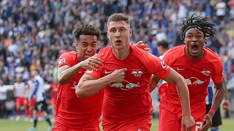 Willi Orban (M) feiert einen Treffer mit Tyler Adams (l) und Mohamed Simakan (r).