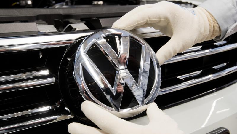 Endmontage im VW-Werk Wolfsburg. Ein Mitarbeiter montiert ein VW Logo an die Front eines VW Tiguan. Endmontage im VW-Werk Wolfsburg. Ein Mitarbeiter montiert ein VW Logo an die Front eines VW Tiguan.