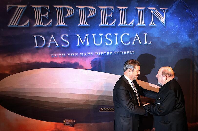 Markus Söder, bayerischer Ministerpräsident und CSU-Vorsitzender (l), wird vor der Weltpremiere des Musicals "Zeppelin", von dessen Komponisten Ralph Siegel, begrüßt.