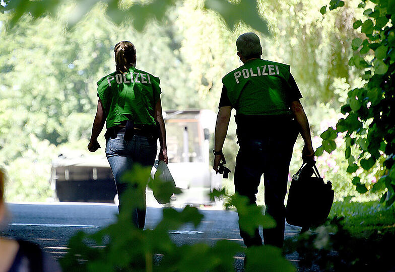 Polizeibeamte gehen am 01.07.2015 in Heikendorf (Schleswig-Holstein) zu einem Villengrundstück. Auf dem Gelände sollen sich Waffen aus dem Zweiten Weltkrieg befinden.