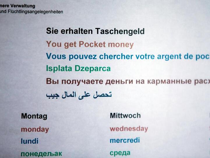 Ein Hinweisschild informiert in einer Erstaufnahmeeinrichtung für Flüchtlinge über die Zeiten der Taschengeld-Ausgabe.