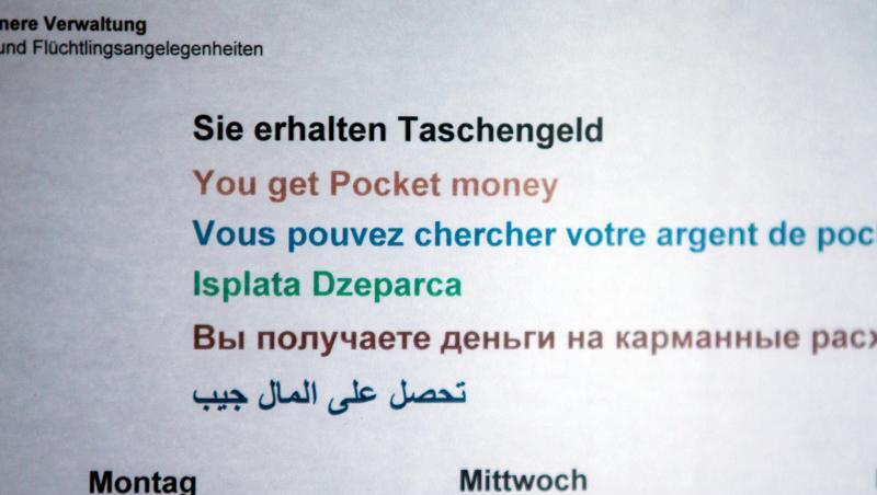 Ein Hinweisschild informiert in einer Erstaufnahmeeinrichtung für Flüchtlinge über die Zeiten der Taschengeld-Ausgabe. Ein Hinweisschild informiert in einer Erstaufnahmeeinrichtung für Flüchtlinge über die Zeiten der Taschengeld-Ausgabe.