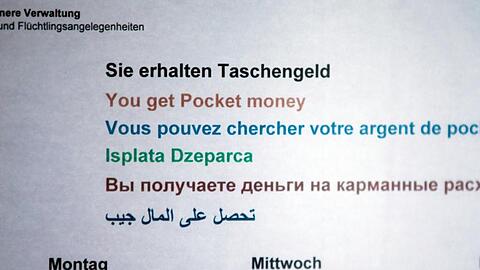 Ein Hinweisschild informiert in einer Erstaufnahmeeinrichtung für Flüchtlinge über die Zeiten der Taschengeld-Ausgabe.