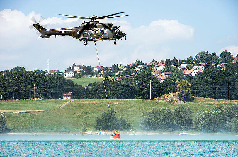 Ein Schweizer Militärhubschrauber holt Wasser für durstende Kühe aus dem Genfer See. Letzte Woche wurde dafür auch französisches Staatsterritorium angesteuert.