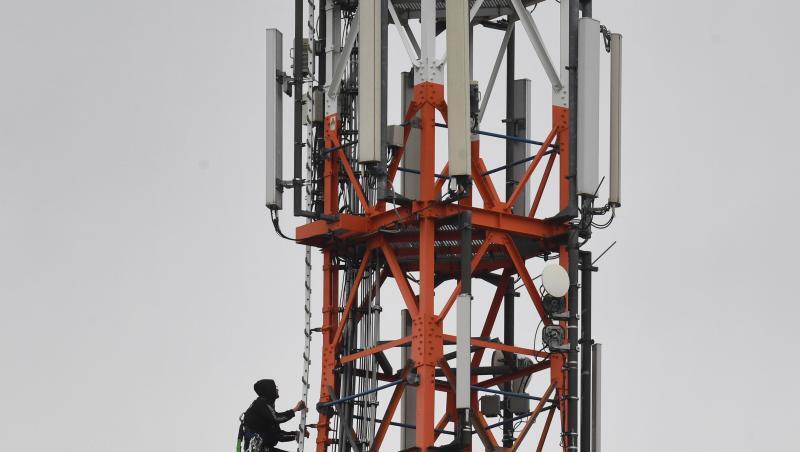 Ein Techniker klettert an einem Funkmast neben Mobilfunkantennen für den Mobilfunkstandard 5G. Ein Techniker klettert an einem Funkmast neben Mobilfunkantennen für den Mobilfunkstandard 5G.