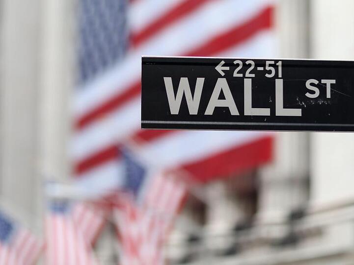 Blick auf die Börse in New York hinter dem Straßenschild der Wall Street.