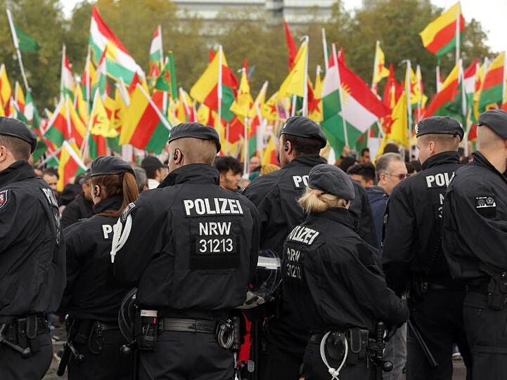 Polizisten beobachten in Köln eine Demonstration gegen die türkische Offensive.