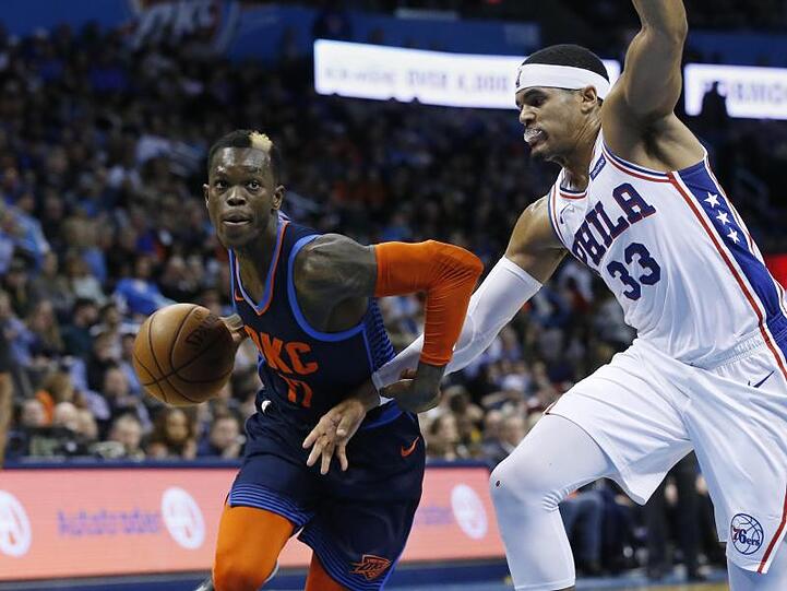 Thunder-Guard Dennis Schröder (l) behauptet sich mit dem Ball gegen Tobias Harris von den und Philadelphia 76ers.