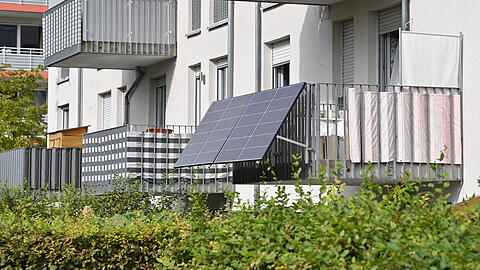 Solarpanels an einem Balkon eines Münchner Wohnblocks: Solche Anlagen können die eigene Stromrechnung senken. Die Anschaffung wird in manchen Ländern, Landkreisen oder Kommunen bezuschusst.
