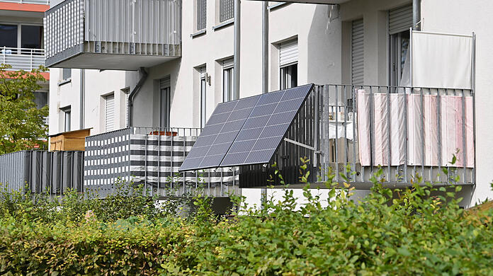 Solarpanels an einem Balkon eines Münchner Wohnblocks: Solche Anlagen können die eigene Stromrechnung senken. Die Anschaffung wird in manchen Ländern, Landkreisen oder Kommunen bezuschusst.