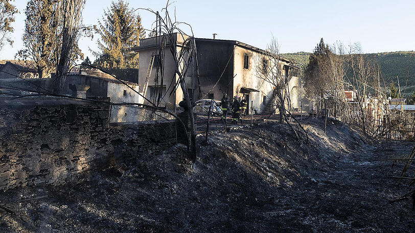 In Tivoli entdeckten Feuerwehrleute zwei Leichen in einem Haus. Italien wird seit Wochen von Waldbränden geplagt.