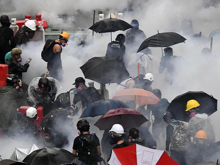 Demonstranten versuchen sich vor Tränengas zu schützen.