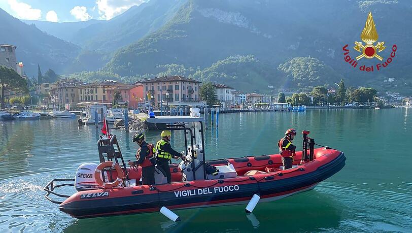 Feuerwehrleute fahren mit einem Boot über den Iseosee.